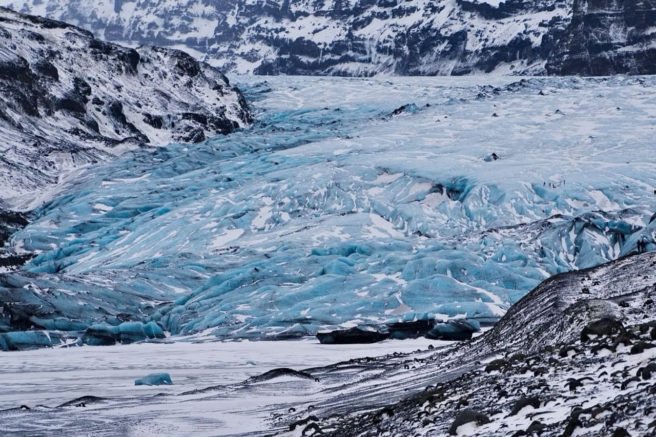 Jęzor lodowca Sólheimajökull, błękitny lód z ciemnymi smugami pyłu wulkanicznego
